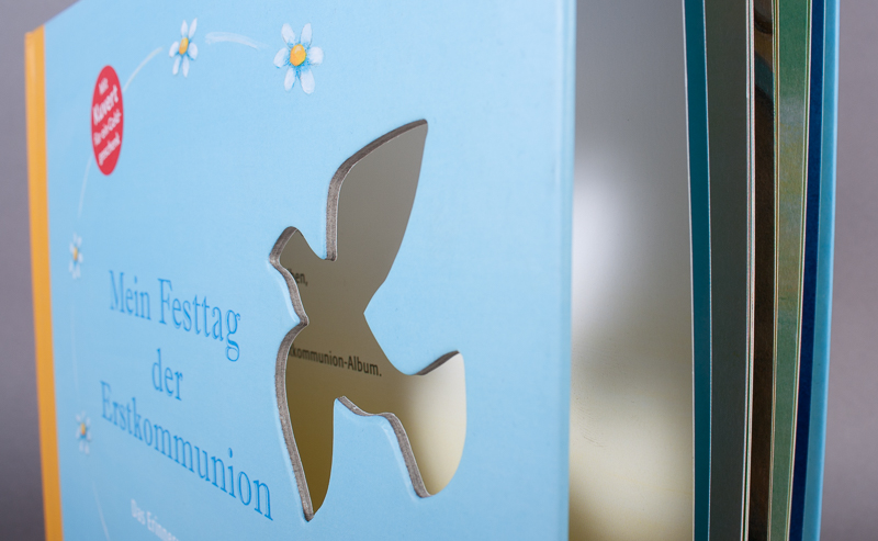 Buchveredelung: Hardcover-Buch Ausstanzung in der Buchdecke in Form einer Taube